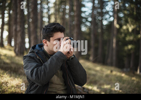 Mann in Wald Aufnehmen von Fotos Stockfoto