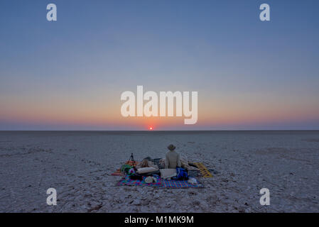 Mann beobachtet Sonnenaufgang auf Makgadikgadi Salzpfannen, Botswana Stockfoto