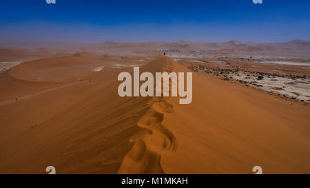 Mann, der entlang einer Sanddüne geht, Deadvlei bei Sossusvlei, Namib Naukluft National Park, Namibia Stockfoto