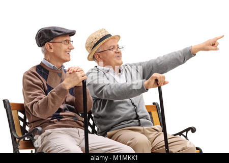 Senior auf einer Bank etwas Übersicht zu einem anderen älteren auf weißem Hintergrund sitzt Stockfoto