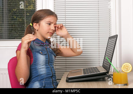 Kleines Mädchen mit Laptop müde Stockfoto