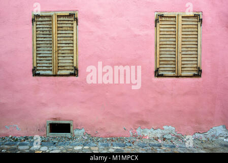 Zwei hölzerne Fensterläden auf einem alten Pink House Stockfoto