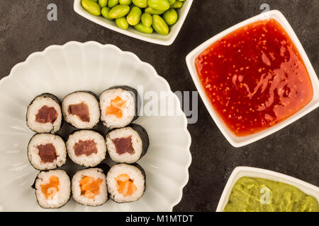 Im japanischen Stil Maki Lachs und Thunfisch Sushi Rollen vor einem schwarzen Hintergrund Stockfoto