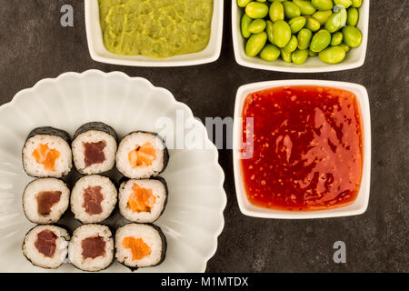 Im japanischen Stil Maki Lachs und Thunfisch Sushi Rollen vor einem schwarzen Hintergrund Stockfoto