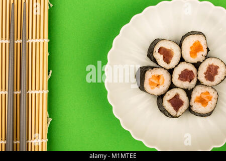 Im japanischen Stil Maki Lachs und Thunfisch Sushi Rollen vor einem grünen Hintergrund Stockfoto