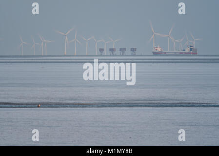 Kentish Flats Offshore Wind Farm und Red Sands Maunsell Forts an der Mündung des Thames Estuary aus der Essex und Kent Küsten. Frachtschiff vorbei Stockfoto