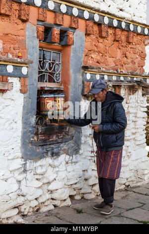 Bumthang, Bhutan. Man Spinnen Gebetsmühlen an Jambey Lhakhang Tempel und Kloster, in der Nähe von jakar. Stockfoto