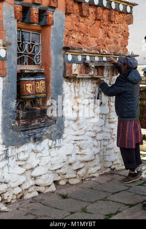 Bumthang, Bhutan. Man bewegliche Steine, um die Anzahl von Zeiten hat gesponnen Gebetsmühlen an Jambey Lhakhang Tempel und Kloster, in der Nähe von jakar. Stockfoto