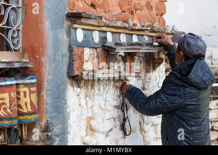 Bumthang, Bhutan. Man bewegliche Steine, um die Anzahl von Zeiten hat gesponnen Gebetsmühlen an Jambey Lhakhang Tempel und Kloster, in der Nähe von jakar. Stockfoto