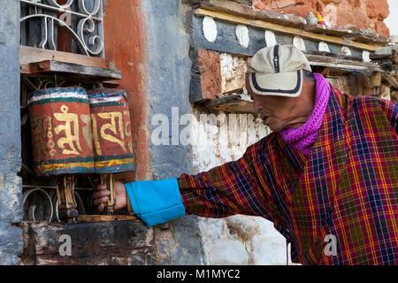 Bumthang, Bhutan. Man Spinnen Gebetsmühlen an Jambey Lhakhang Tempel und Kloster, in der Nähe von jakar. Stockfoto