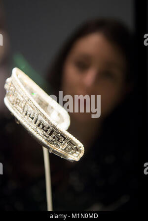 Ein Mitarbeiter des Victoria and Albert Museums sieht Tiara, 1909, während eines Fotoaufrufs für die neue Ausstellung Ocean Liners: Speed and Style der V&A, die sich im Besitz von Lady Marguerite Allan (1873-1957) befindet. Stockfoto