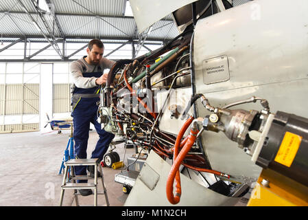 Fluggerätmechaniker Reparaturen Triebwerk in einem Flughafen Hangar Stockfoto