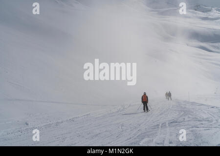 Skifahrer, verschwindet in den Nebel und niedrige Wolke auf einer Piste in Les Menuires in den drei Täler Skigebiet von Frankreich auf einem sonnigen, hellen Tag Stockfoto