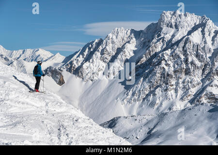 Skifahren off piste in der Nähe von Meribel in die drei Täler Skigebiet in Frankreich. Ein Skifahrer steht an der Spitze eines steilen Schneehang abgedeckt. Stockfoto