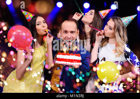 Ein Kerl und drei Mädchen freuen und die Party in der Nacht Club feiern. Stockfoto