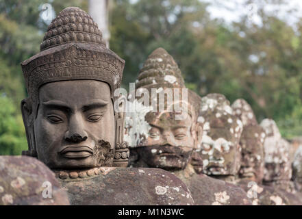 Gesichter Gottes Statuen entlang der Steinernen Brücke vor dem Südtor von Angkor Thom, Kambodscha Stockfoto