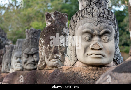 Reihe von Daemon Statuen entlang der Brücke aus Stein vor dem Südtor von Angkor Thom, Kambodscha Stockfoto