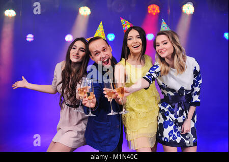 Ein Kerl und drei Mädchen freuen und die Party in der Nacht Club feiern. Stockfoto