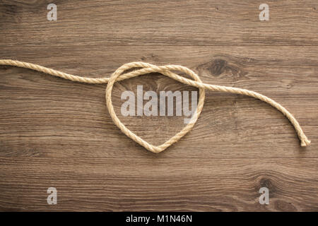 Herzform aus Seil auf altem Holz Stockfoto