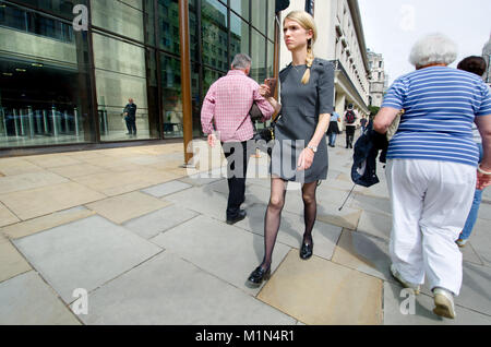 London, England, UK. Gut gekleidete junge Frau, die in den Aktionsbereich, vorbei an Coutts Bank Stockfoto