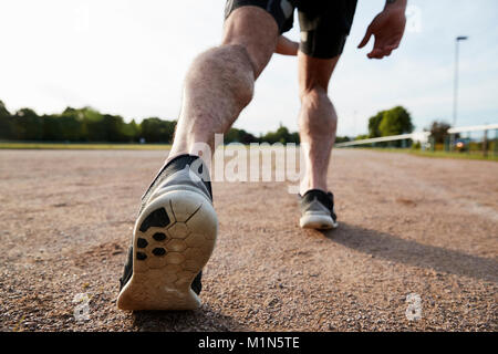 Niedrige Abschnitt der Beine bereit, auf eine Spur zu führen Sie das männliche Läufer Stockfoto