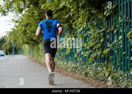 Rückansicht der jungen männlichen Athleten auf der Straße läuft Stockfoto