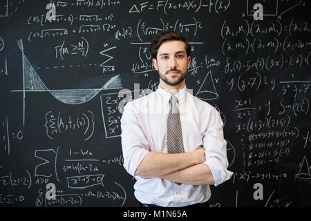 Junger Mann mit Kamera vor einer Tafel auf der Suche Stockfoto