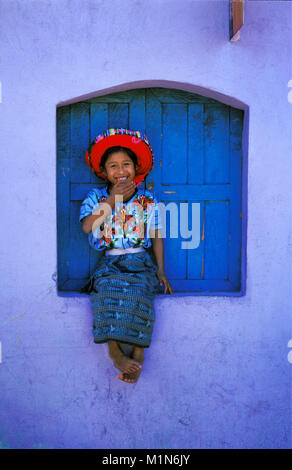 Guatemala. Santiago de Atitlšn. Lago de Atitlan. Maya Mädchen sitzen im Fenster mit den typischen Hut. Stockfoto