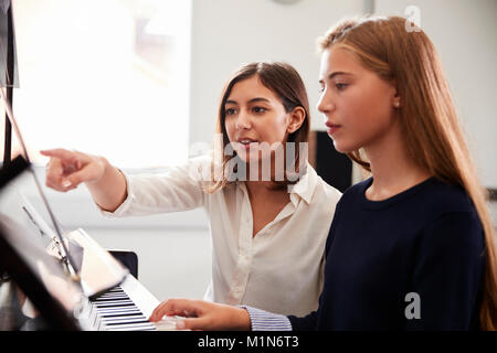 Weibliche Schüler mit Lehrer spielen Klavier in der Musik Lektion Stockfoto