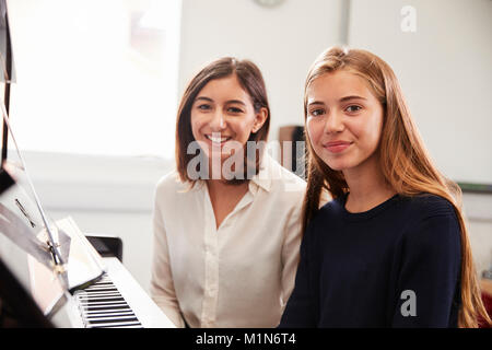 Porträt der Schüler mit dem Lehrer spielen Klavier in der Musik Lektion Stockfoto