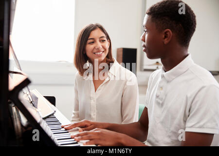 Männliche Schüler mit Lehrer spielen Klavier in der Musik Lektion Stockfoto