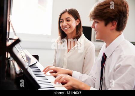 Männliche Schüler mit Lehrer spielen Klavier in der Musik Lektion Stockfoto