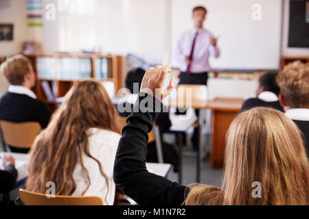 Studentin anheben Hand in Frage stellen im Klassenzimmer Stockfoto