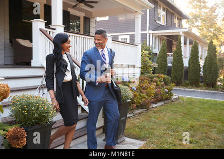 Business Paar verlassen Suburban House für den Weg zur Arbeit Stockfoto