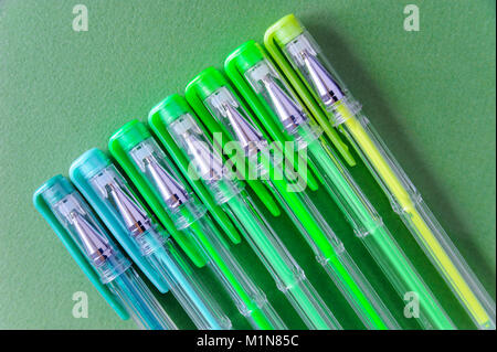 Kugelschreiber in verschiedenen Farben auf einem grünen Hintergrund. Stockfoto