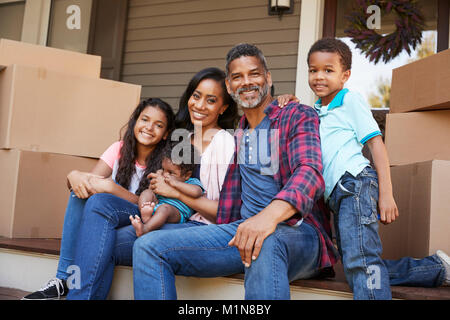 Familie mit Kindern ausserhalb des Hauses am Umzugstag Stockfoto