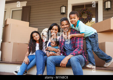 Familie mit Kindern und Hund ausserhalb des Hauses am Umzugstag Stockfoto