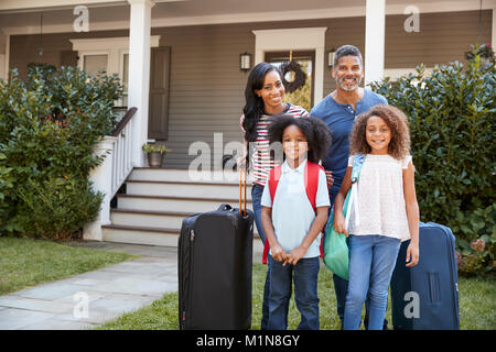 Porträt der Familie mit Gepäck verlassen Haus für Ferienhäuser Stockfoto