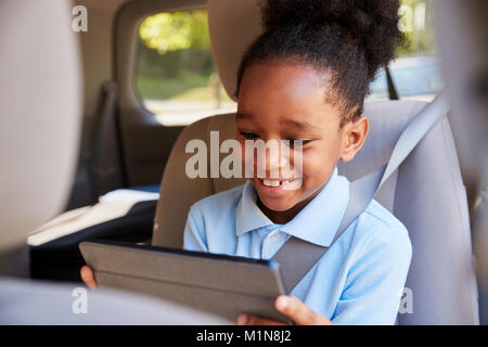Junge mit digitalen Tablette auf dem Auto Stockfoto