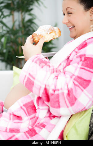 Lächelnd schwangere Frau Frühstück im Bett Stockfoto