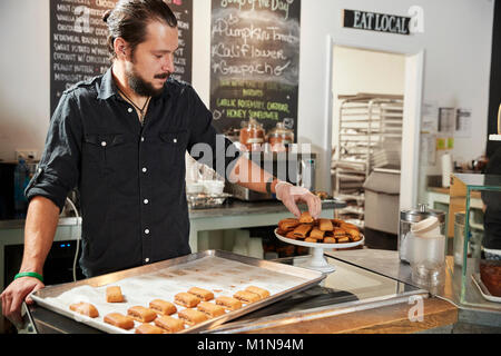 Kellner hinter der Theke im Coffee Shop Vermittlung von Cookie anzeigen Stockfoto