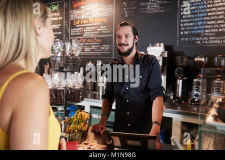 Kellner's unter weiblichen Kundenauftrag im Coffee Shop Stockfoto