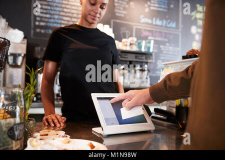 Kunden zahlen im Coffee Shop mit Kreditkarte Stockfoto