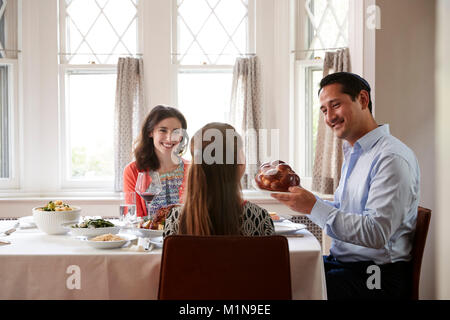 Jüdischen Mann, challah Brot am Schabbat Mahlzeit mit der Familie Stockfoto