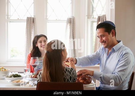 Jüdischen Mann teilen challah Brot mit Familie am Schabbat Mahlzeit Stockfoto