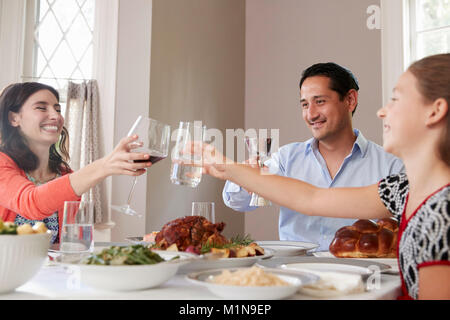 Jüdische Familie Gläser heben am Tisch für Schabbat Mahlzeit Stockfoto