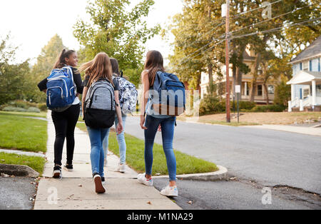 Vier junge jugendlich Mädchen zu Fuß zur Schule zusammen, Rückansicht Stockfoto