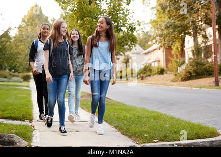 Vier junge jugendlich Mädchen zu Fuß zur Schule zusammen, Vorderansicht Stockfoto
