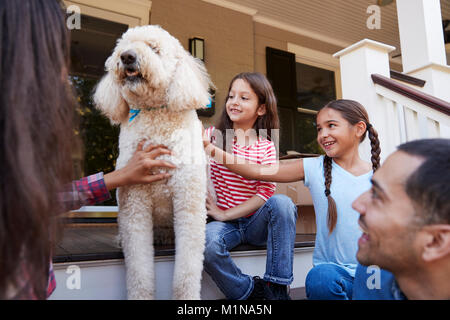 Familie mit Hund sitzen auf die Schritte der neuen Heimat unter Umzug in Tag Stockfoto