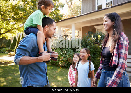 Vater Sohn Fahrt auf Schultern, als Familie Haus verlassen Stockfoto